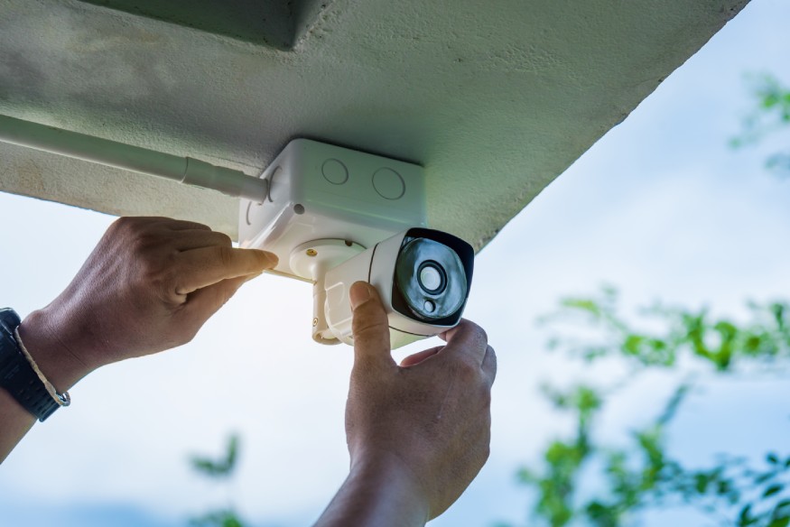 una persona que instala una cámara de seguridad para mejorar la seguridad del patio trasero