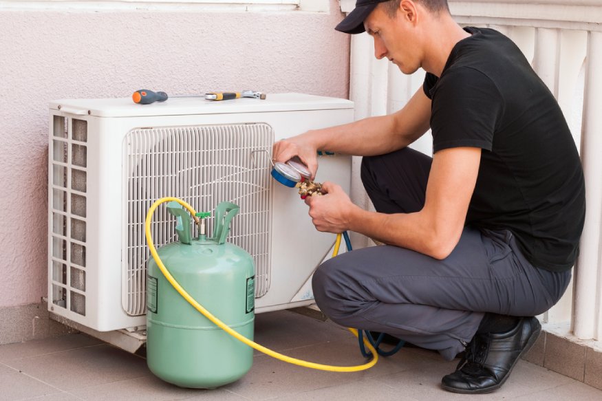 un técnico de HVAC agregando más refrigerante