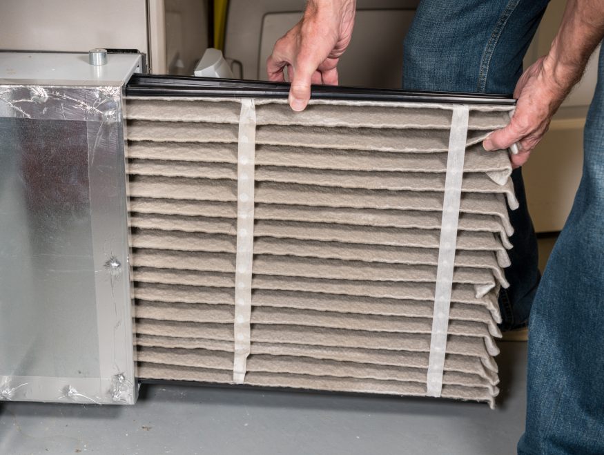 un propietario reemplazando el filtro sucio de HVAC