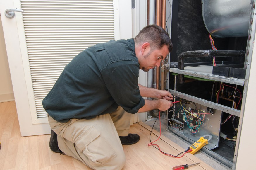 Reparador profesional de HVAC que inspecciona la unidad de HVAC