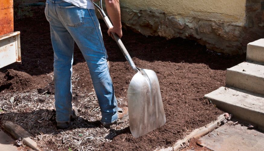 Una persona paleando y agregando compost al suelo anaeróbico
