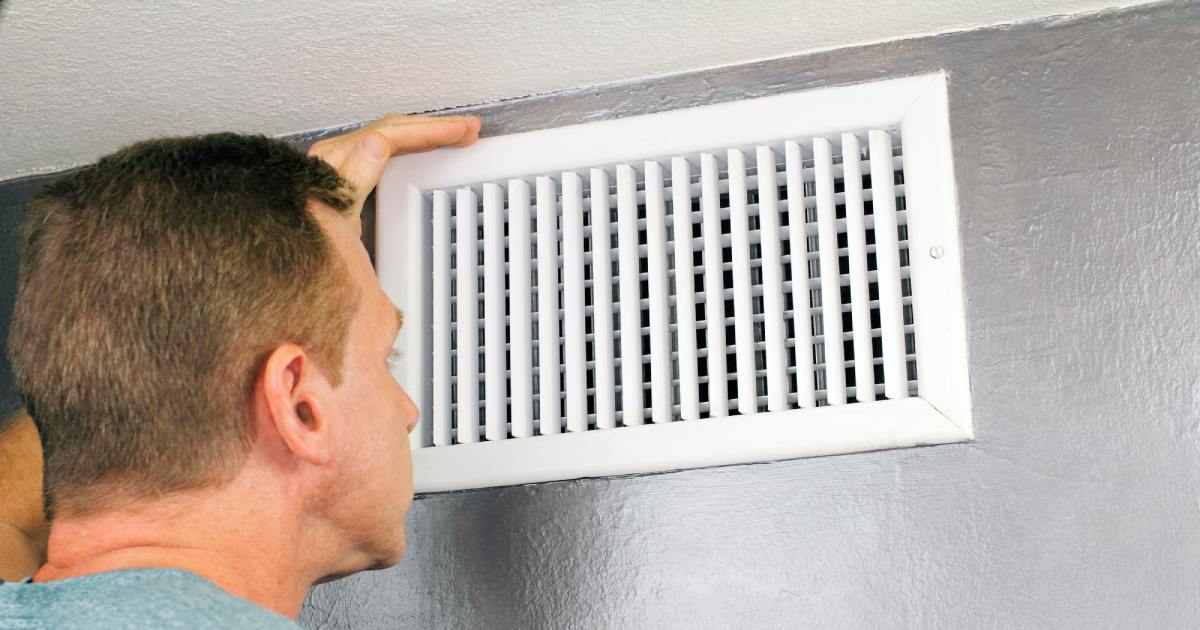 una persona inspeccionando por qué el aire frío proviene de eventos cuando la calefacción está apagada