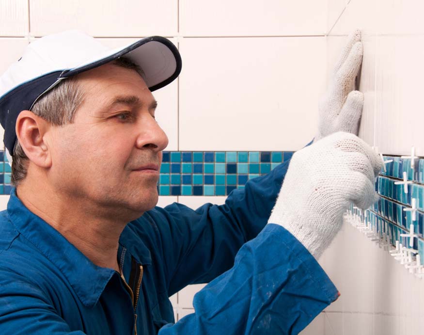 hombre instalando azulejos de pared de baño